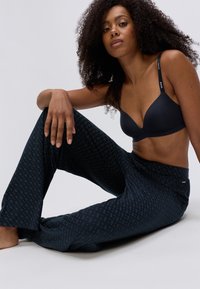 Navy-mønstret loungebukser har en løs pasform og blød tekstur, og de bliver parret med en matchende navy bh med justerbare stropper.