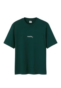 T-shirt vert à manches courtes en coton, avec un col rond et un texte brodé blanc "Keith Haring" sur la poitrine.
