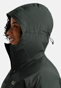 Dunkelgraue wasserdichte Jacke mit Kapuze, verstellbaren Kordeln und glatter Textur. Seitenansicht, die den Reißverschluss und die Nähte hervorhebt.