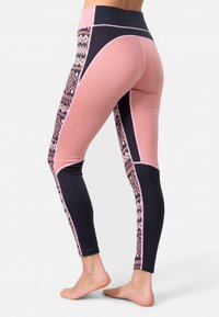 Legginsit vaaleanpunaisena ja tummansinisenä, joissa on geometrisia kuvioita sivuilla, valmistettu joustavasta kankaasta ja korkea vyötärö.