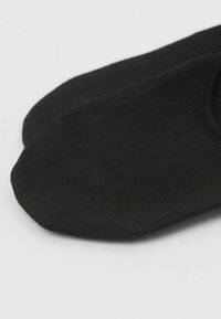 Calcetines negros hasta el tobillo, hechos de una tela suave y elástica, con un diseño sin costuras y una textura lisa, con puntera y talón redondeados.