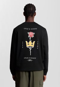 Schwarzer Sweatshirt mit einem grafischen Design, das eine rote Rose und eine gelbe Krone zeigt. Der Text enthält "Lyle & Scott" und "Rose Crown" in Weiß.