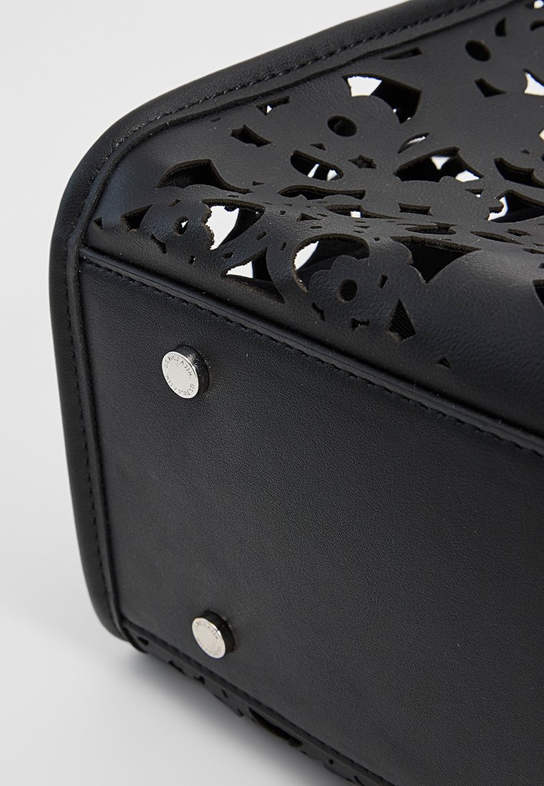 Schwarze Handtasche mit aufwändigem durchbrochenem Blumenmuster, glattem Lederfinish, silbernen Hardware-Akzenten und Metallnieten am Boden.