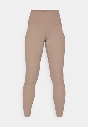 Beige træningsleggings med en høj, glat talje. De er lavet af strækbart stof og har et tætsiddende design, der strækker sig ned til anklerne.