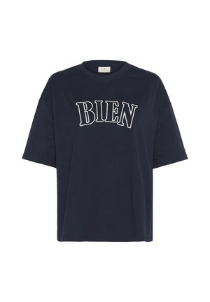 Tums zils kokvilnas T-krekls ar īsām piedurknēm un brīvu piegriezumu. Priekšā ir balta izšūta teksta "BIEN" izliekta dizainā.