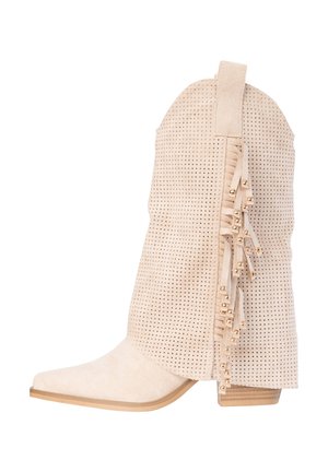Beige suède cowboylaars met geperforeerde bovenzijde, decoratieve franjes met gouden kralen, puntige neus en gestapelde lage hak.