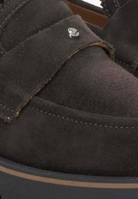 Brązowe zamszowe loafersy z wyhaftowanym wzorem, z metalowym akcentem i wyściełaną czarną gumową podeszwą. Miękka tekstura i płaski kształt.