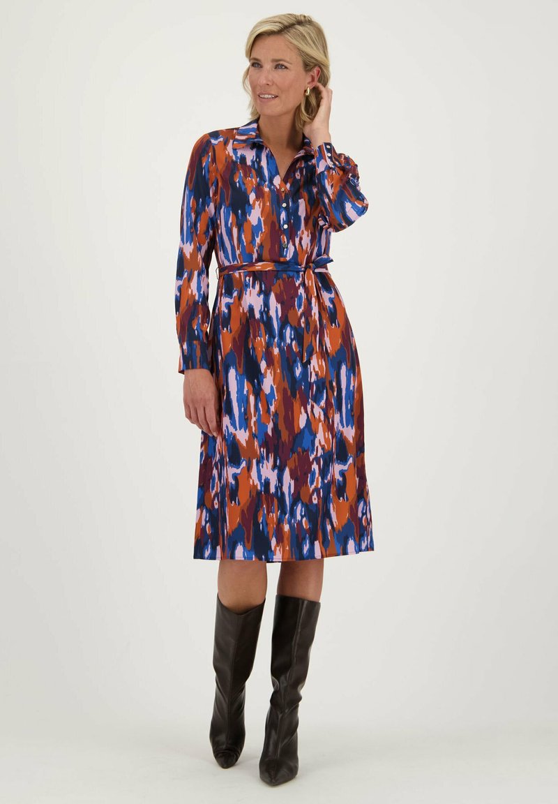 Shirtdress in een kleurrijke print met tinten blauw, oranje en paars; lange mouwen, knoopsluiting aan de voorkant, ceintuur op de taille, tot de knie.