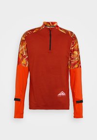 Langärmliges Sportoberteil in verbranntem Orange mit gemustertem Schulterbereich in Rot- und Gelbtönen, verfügt über einen Viertel-Reißverschluss und reflektierende Logo-Details.