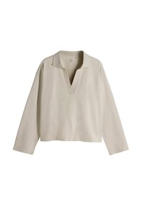 Jersey beige de manga larga, escote en V y cuello. Tela suave con textura lisa, presenta un ajuste relajado y sin patrones o detalles visibles.