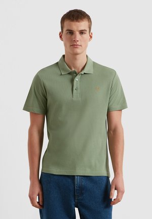 Grünes, geripptes Poloshirt mit klassischem Kragen, Drei-Knopf-Leiste und kleinem, gesticktem Logo auf der linken Brust. Kurze Ärmel.