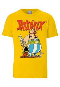 Gelbes Baumwoll-T-Shirt mit einem grafischen Druck von zwei Cartoonfiguren, Asterix und Obelix, und fettem roten "Astérix"-Text darüber.