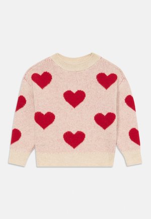 Strikkegenser i lys rosa med store røde hjerte-mønstre. Har rund hals og kremfargede ribbestrikkede mansjetter og kant. Myk tekstur.