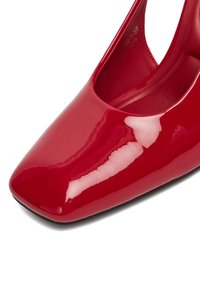 Punane läikiv nahast kontsaking, millel on ruudukujuline varvas ja siledat pinda. Omab minimalistlikku disaini ja kumeraid külgi, mis loovad elegantse silueti.