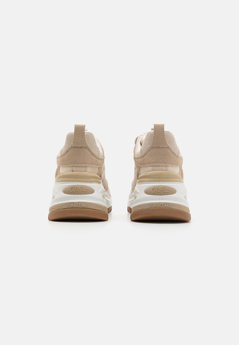 Sneaker beige in suede con accenti in rete, tallone imbottito e suola chunky bianca. Presenta il logo sul tallone e un design con sovrapposizione testurizzata.