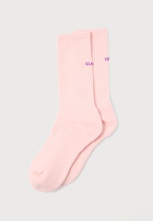 Różowe skarpetki z prążkowaną teksturą, z fioletowym napisem, charakteryzujące się gładką fakturą i zaokrąglonym noskiem.