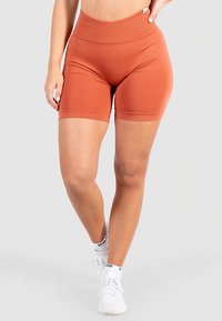 Athletikshorts i rustfarve lavet af strækbart stof, med høj talje og en glat tekstur, med en tætsiddende pasform.