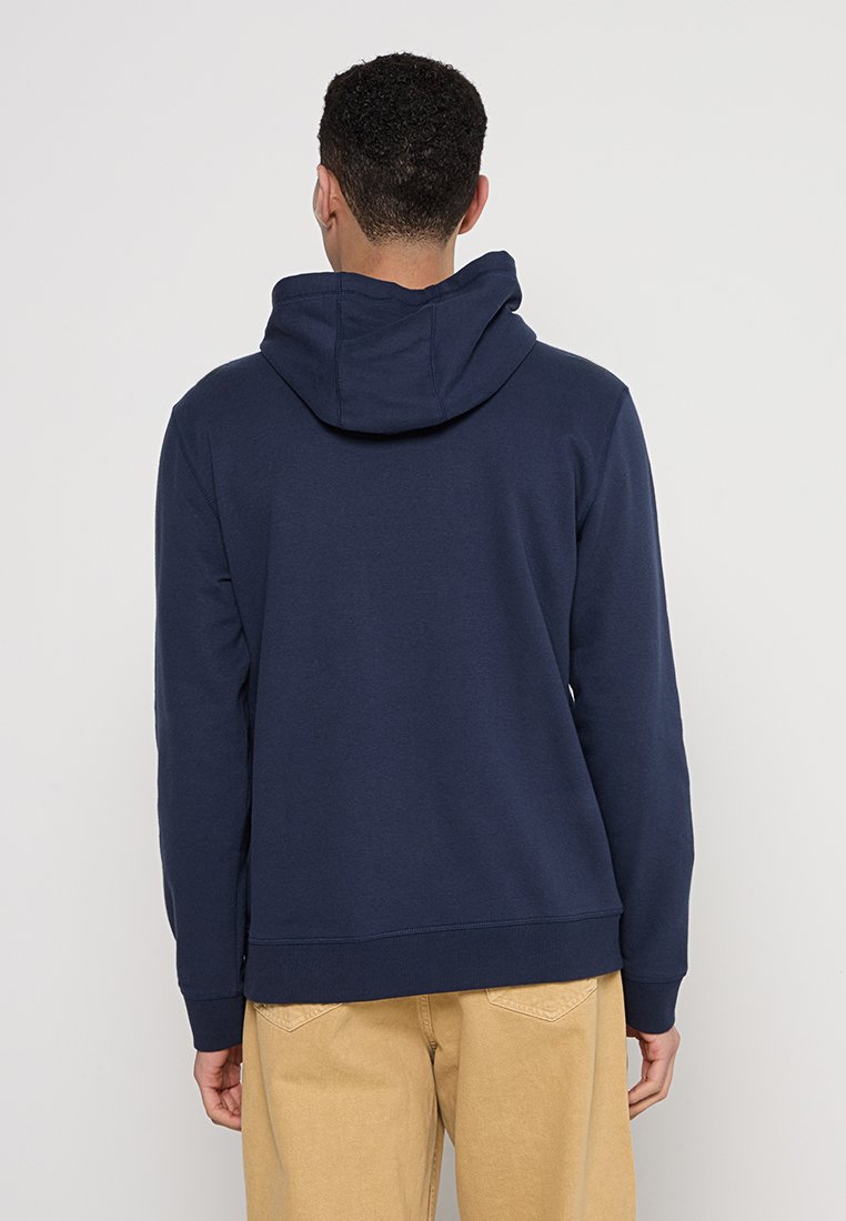 Dunkelblauer Pullover-Hoodie aus weichem Stoff, mit verstellbarem Kapuzenzug, gerippten Bündchen und Saum. Glatte Textur mit minimaler Detailgestaltung.