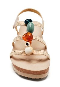 Sandalia de plataforma tejida en color beige con una suela texturizada, que presenta coloridos adornos de cuentas en tonos azul, naranja, crema y detalles en dorado a lo largo de las correas.