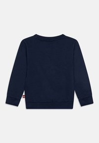 Felpa a maniche lunghe blu navy realizzata in tessuto morbido, con scollo a girocollo ribbed e polsini, e un piccolo etichetta sul lato sinistro.