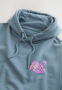 Felpa grigio-blu con un grande logo colorato "PINK FLOYD". Materiale misto cotone, con lacci regolabili con punte metalliche e texture morbida.