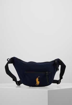 Granatowa nerka z czarnymi regulowanymi paskami, przednią kieszenią na zamek oraz żółtym haftem logo z graczem polo.