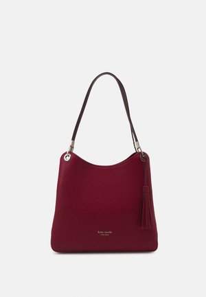Sac à bandoulière en cuir rouge foncé avec une sangle unique foncée, détail pompon sur le côté et logo "kate spade new york" sur le devant.