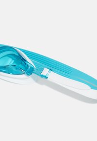 Lunettes de natation avec des verres transparents bleus, de forme incurvée, et des sangles en silicone blanches présentant une texture nervurée pour une meilleure prise.