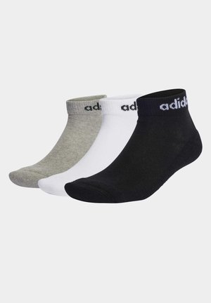 Tres pares de calcetines tobilleros en gris, blanco y negro. Cada par tiene un puño acanalado y presenta el logo de "adidas" en negro en el puño.