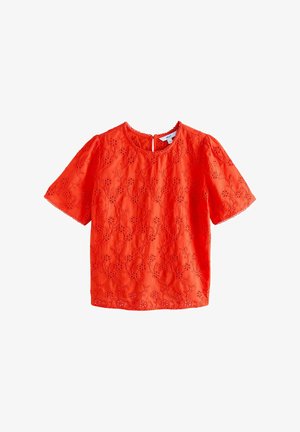 Blusa rossa ricamata a maniche corte con scollatura scallop e motivi floreali su tutta la superficie. Realizzata in tessuto leggero.