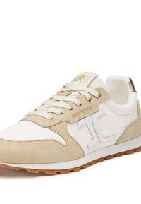 Sneaker bianca e beige con materiali in suede e pelle, punta rotonda, parte anteriore con lacci texture, e accenti dorati del logo sui lati.