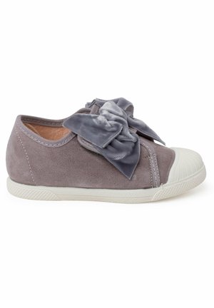 Sneaker in suede grigio con un grande fiocco di velluto grigio sopra. Presenta una punta in gomma bianca e una suola in gomma bianca testurizzata.