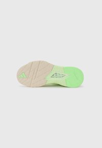 Shoe sole with a beige and light green colorway. Textured patterns and a triangular shape in the center, featuring "TRAXION" branding.