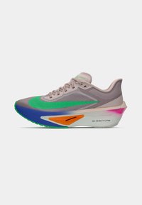 Leichter Laufschuh mit einem beigen Obermaterial, grünen Akzenten und einer mehrfarbigen Sohle mit blauen, orangefarbenen, rosa und lila Details.