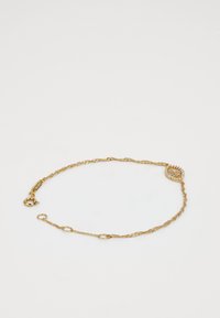 Gold bracelet with twisted chain design, featuring a circular, gem-embellished accent and a claw clasp for secure fastening.