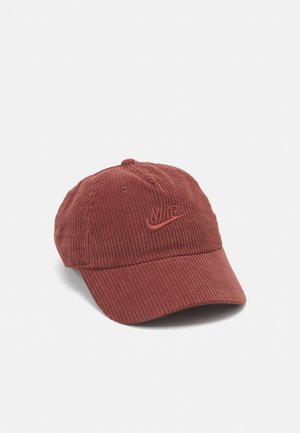 Donkerrode Nike baseballpet met corduroy textuur en geborduurd logo aan de voorkant, getoond tegen een witte achtergrond.