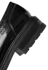 Schwarzer Lacklederschuh mit einer klobigen, strukturierten Gummisohle. Besitzt eine runde Zehenform und eine glatte, glänzende Oberfläche.