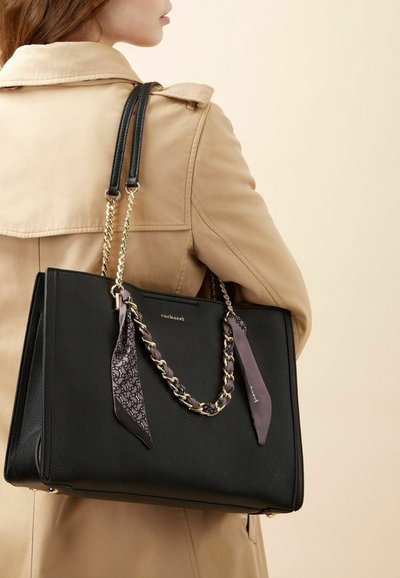 Borsa tote in pelle nera con forma strutturata, caratterizzata da una tracolla a catena dorata e dettagli in tessuto decorato legati ai manici.