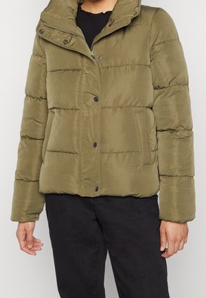 Person wearing olive green puffer jacket with snap buttons and side pockets, paired with black pants.
