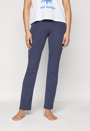 Navy blue stretch leggings dengan desain yang pas. Material katun lembut, tanpa jahitan di pergelangan kaki. Dipadukan dengan kaos grafis putih yang longgar.