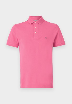 Short pink polo shirt made of cotton, featuring a classic collar, three buttons, and a small logo on the chest.