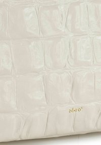 Lichtgrijze tas van krokodillenprintleer met een glanzende textuur. Voorzien van een subtiel gouden logo detail rechtsonder.