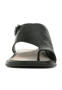 Black leather sandal featuring an open toe, curved straps, and a side buckle. The sole is flat with a contrasting inner color.