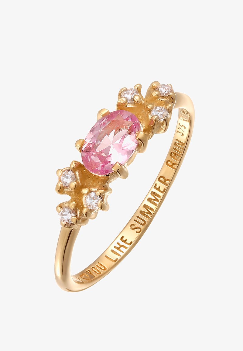 Guldring med en oval rosa ädelsten i mitten, omgiven av mindre klara stenar, med en graverad inre ring.