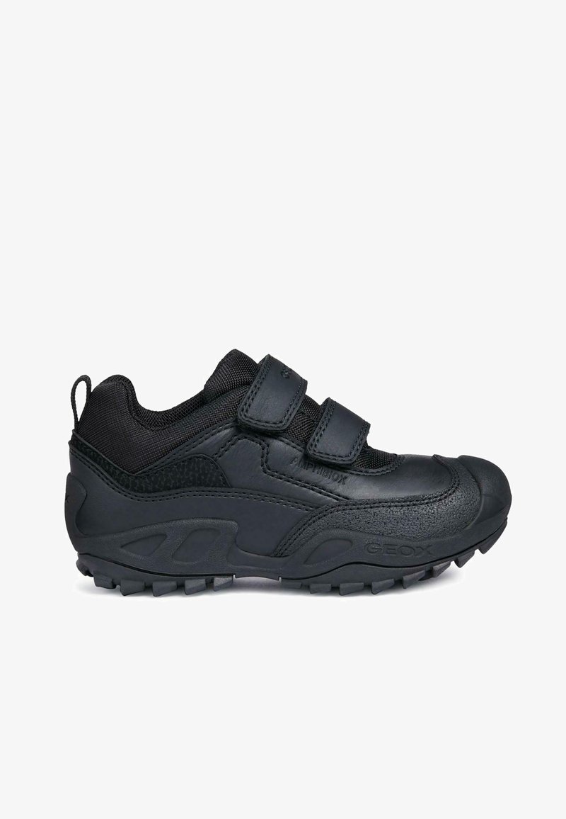 Zapatillas deportivas negras con parte superior de cuero texturizado y malla, que cuentan con dos correas de Velcro, suela de goma con patrones de agarre y puntera reforzada.