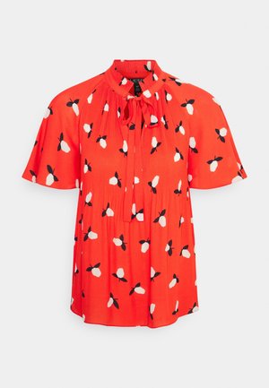 Röd kortärmad blus med hög krage och knytning. Har vita och svarta blommönster samt en veckad design. Lättviktsmaterial.