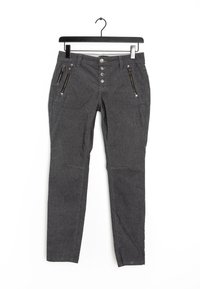 Pantalon gris fuselé en tissu texturé, avec trois poches zippées et une fermeture à cinq boutons, suspendu à un cintre noir.