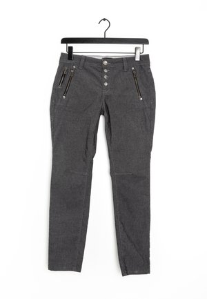 Pantalon gris fuselé en tissu texturé, avec trois poches zippées et une fermeture à cinq boutons, suspendu à un cintre noir.