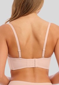 Světlý růžový bralet s nastavitelnými popruhy, zapínáním na háček a oko na zadní straně, hladkou texturou a minimálními detaily.