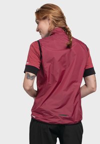 Burgunderfarbene ärmellose Jacke mit hohem Kragen, schwarzen Armakzenten und reflektierendem Streifen auf der Rückseite, aus leichtem, wasserabweisendem Material gefertigt.